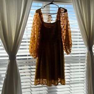 Swiss dot shirted bodice midi dress in a dark yellow color.